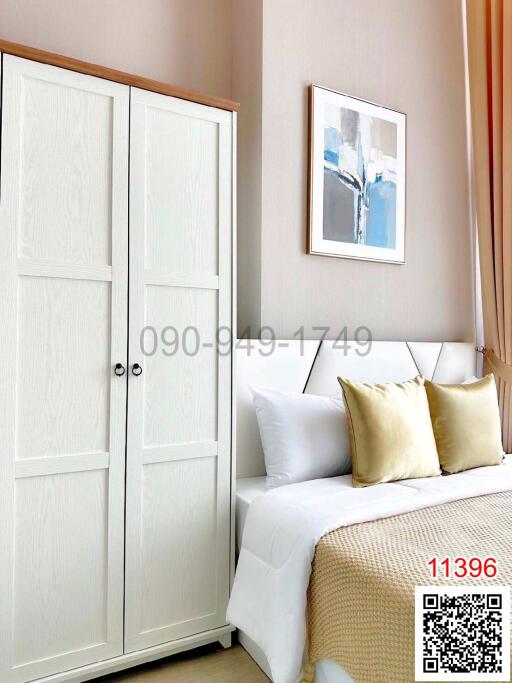 Cozy bedroom interior with white door, decorative pillows, and art on the wall