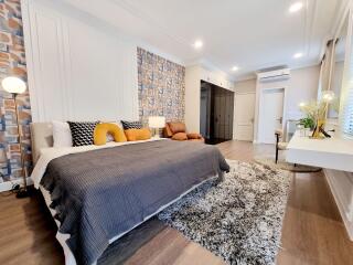 Modern bedroom interior with a well-decorated bed, a plush rug, and stylish lighting