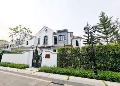 Elegant two-story house with a gated entrance and landscaped front yard