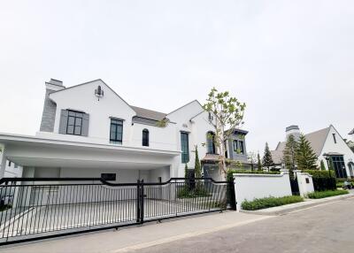Exterior view of modern white two-story house with a gate