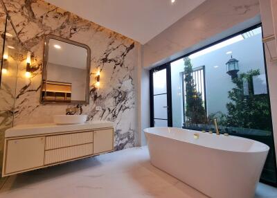 Spacious modern bathroom with freestanding bathtub and garden view