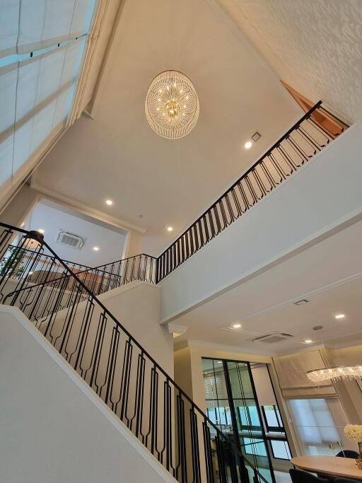 Modern interior with high ceilings, chandelier, and staircase