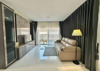 Spacious, well-lit living room with modern furniture and balcony access