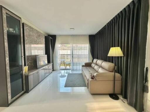 Spacious, well-lit living room with modern furniture and balcony access
