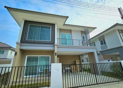 Modern two-story residential house with a balcony and carport