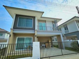 Modern two-story residential house with a balcony and carport