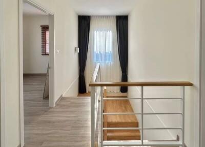 Bright hallway with staircase and hardwood floors