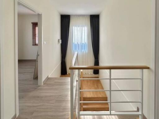 Bright hallway with staircase and hardwood floors