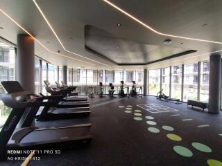 Modern gym facility inside a residential building with exercise equipment and large windows
