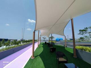 Modern rooftop lounge area with shading sails and city view