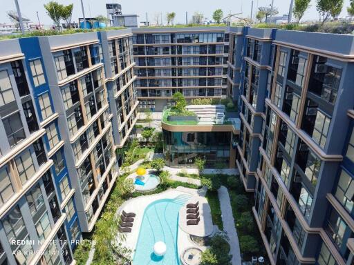 Modern residential complex with central courtyard featuring a swimming pool and garden
