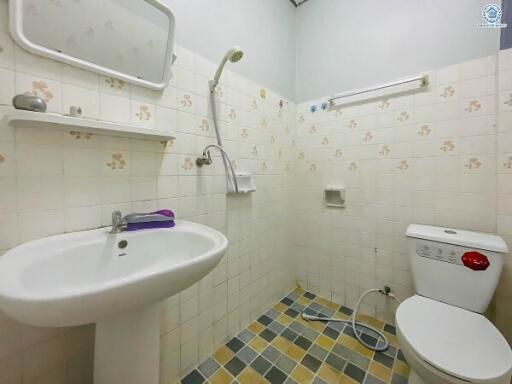 Compact bathroom with essential fixtures and tiled flooring