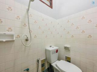 Small bathroom with basic fixtures and tiled walls