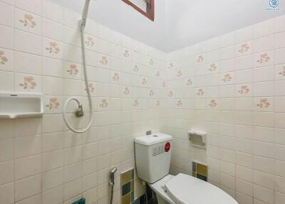 Small bathroom with basic fixtures and tiled walls