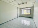 Empty office space with large windows and tiled flooring