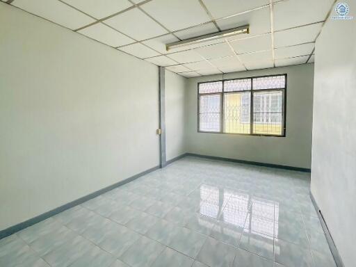 Empty office space with large windows and tiled flooring