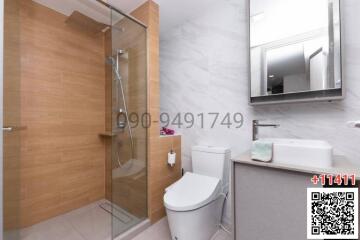 Modern bathroom interior with glass shower, wooden elements, and white fittings
