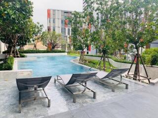 Modern outdoor swimming pool area with lounge chairs and landscaping