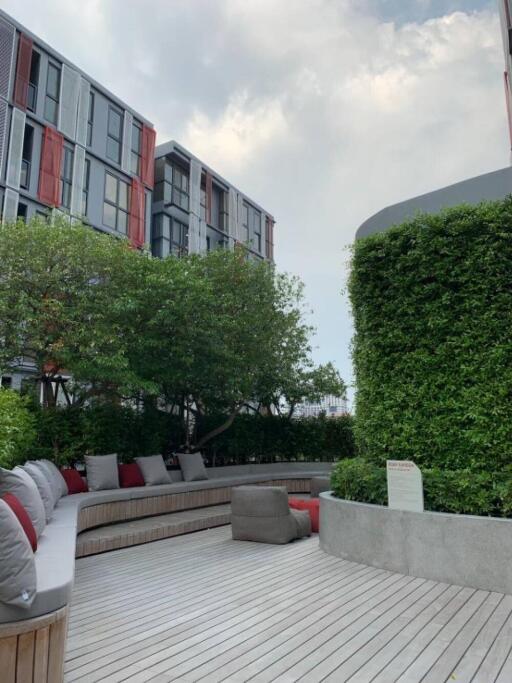 Modern outdoor lounge area with seating and landscaping near buildings