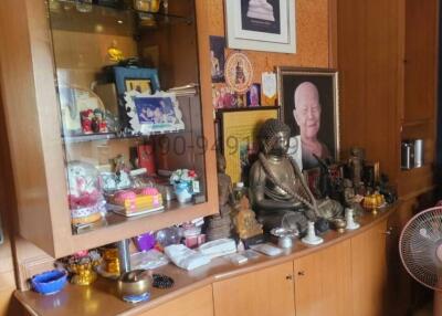 Living room with display cabinet showcasing personal memorabilia and religious statues