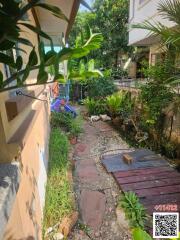 Paved garden pathway with lush green plants and garden decor in a residential outdoor space