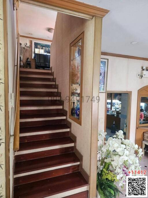 Elegant wooden staircase with white floral decoration in a well-kept house interior