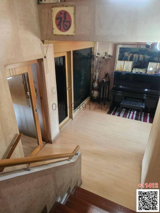 Spacious living room with wooden flooring and piano