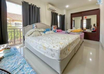 Spacious bedroom with a large bed, shiny tiled flooring, and a view from the window