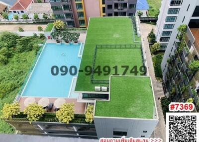 Aerial view of residential building with pool and green space