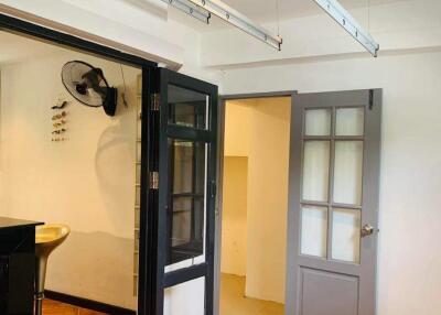 Interior view of a home showing an entrance area with tiled flooring, glass door and artistic wall decor