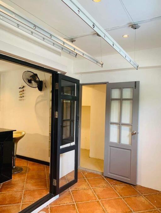 Interior view of a home showing an entrance area with tiled flooring, glass door and artistic wall decor