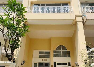 Elegant yellow townhouse with a balcony and large windows