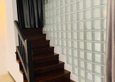 Elegant staircase with wooden steps and glass block wall