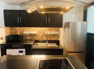 Modern kitchen with stainless steel appliances and mosaic backsplash