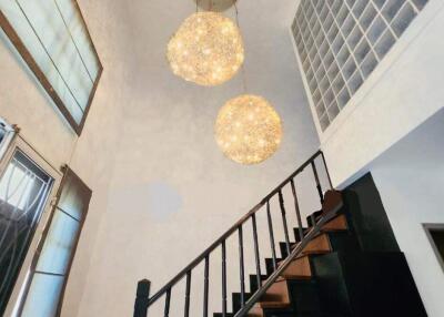 Modern staircase with decorative hanging lights and high ceiling