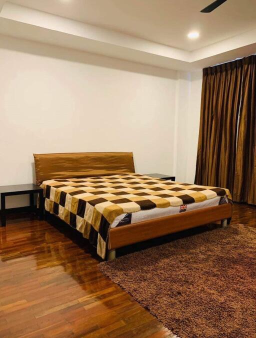 Spacious bedroom with wooden flooring and king-sized bed