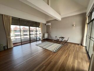 Spacious living room with large windows and hardwood floors