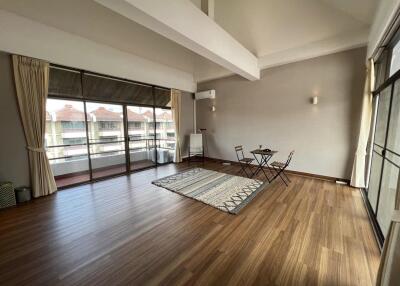 Spacious living room with large windows and hardwood floors