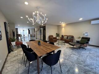 Spacious modern living room with dining area and elegant light fixture