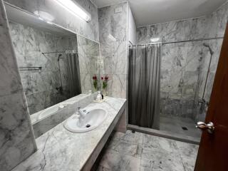 Modern bathroom with marble tiles and glass shower