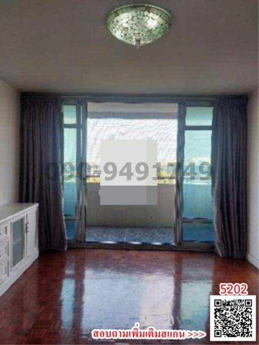 Spacious bedroom with large window and polished floor
