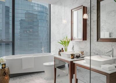 Modern bathroom with marble walls, a white bathtub, and elegant decor