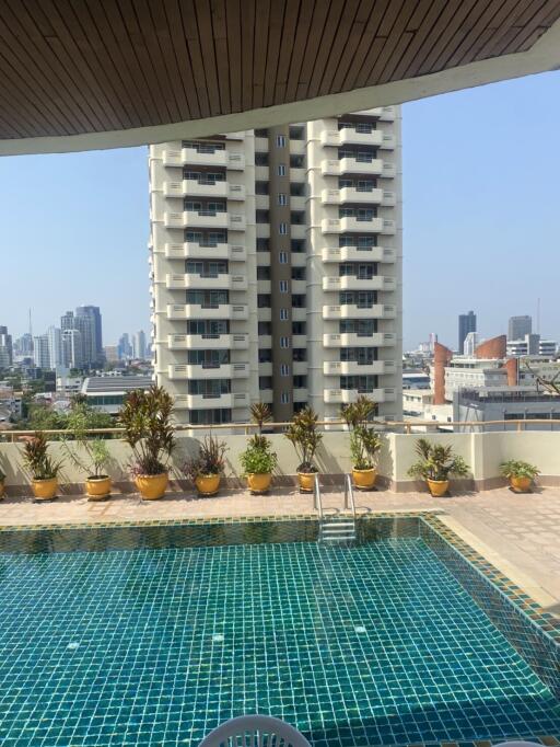 Urban balcony overlooking a pool and neighboring high-rise buildings