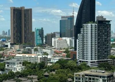 Panoramic view of a vibrant city skyline with modern high-rise buildings and clear blue sky