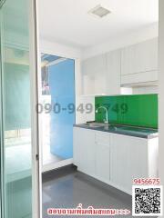 Modern kitchen with white cabinets and green backsplash