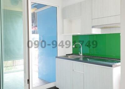 Modern kitchen with white cabinets and green backsplash