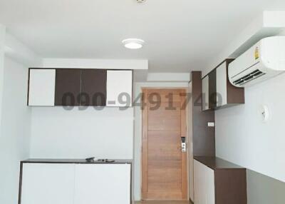 Modern compact kitchen in an apartment with wooden door and ceramic flooring