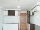 Modern compact kitchen in an apartment with wooden door and ceramic flooring