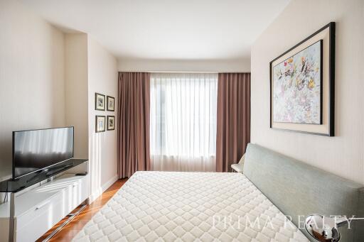 Modern bedroom with large bed and window drapes