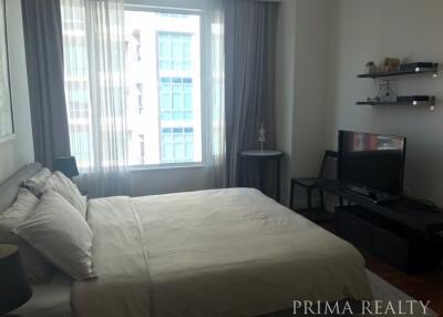 Spacious bedroom with large bed, natural lighting, and modern amenities